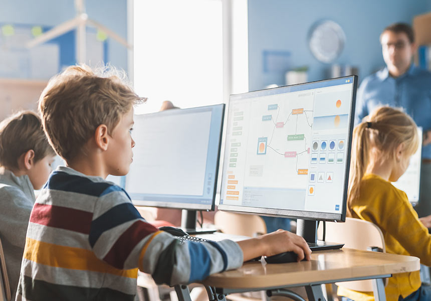Student kreslí diagramy na počítači ve třídě