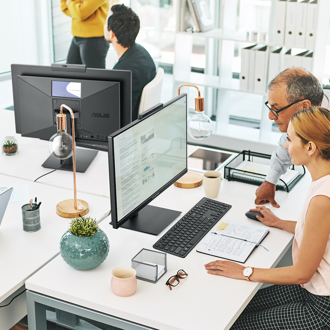 En la oficina de una pequeña empresa, los empleados están trabajando o discutiendo entre ellos.