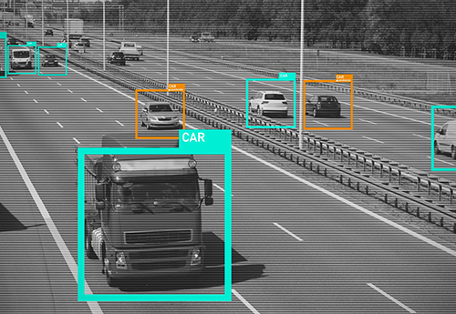 On the highway, trucks and cars are monitored by Intelligent Video Analytics