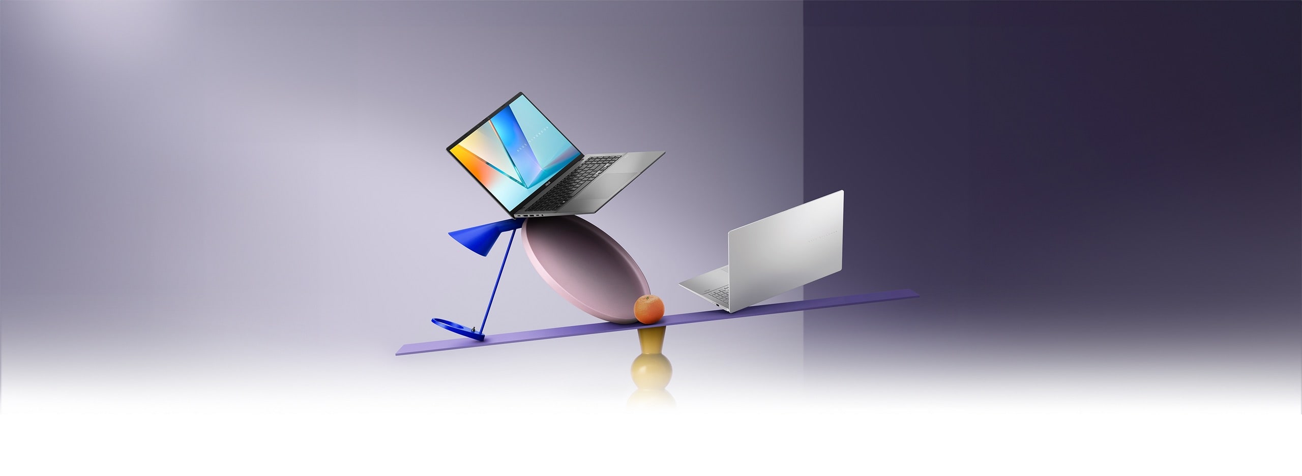 Matte Gray Vivobook S16 is open, and Cool Silver Vivobook S16 is closed, balanced on a colorful, artistic seesaw with geometric shapes and an orange fruit, set against a soft purple gradient background.