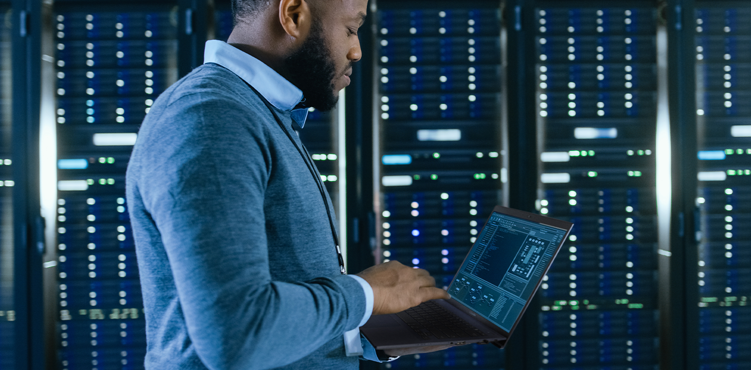 An IT staff holding ASUS ExpertBook laptop on hand is walking in a data center.