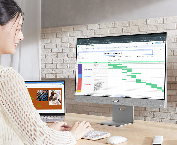 A young professional works on her laptop, using the ASUS ZenScreen Smart Monitor MS27UC as a larger second screen.