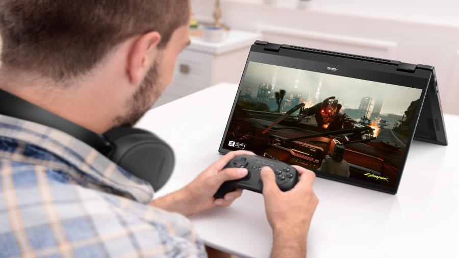 A man is having a joystick and earphones with an ASUS Chromebook Vibe CX55 Flip in tent mode. 