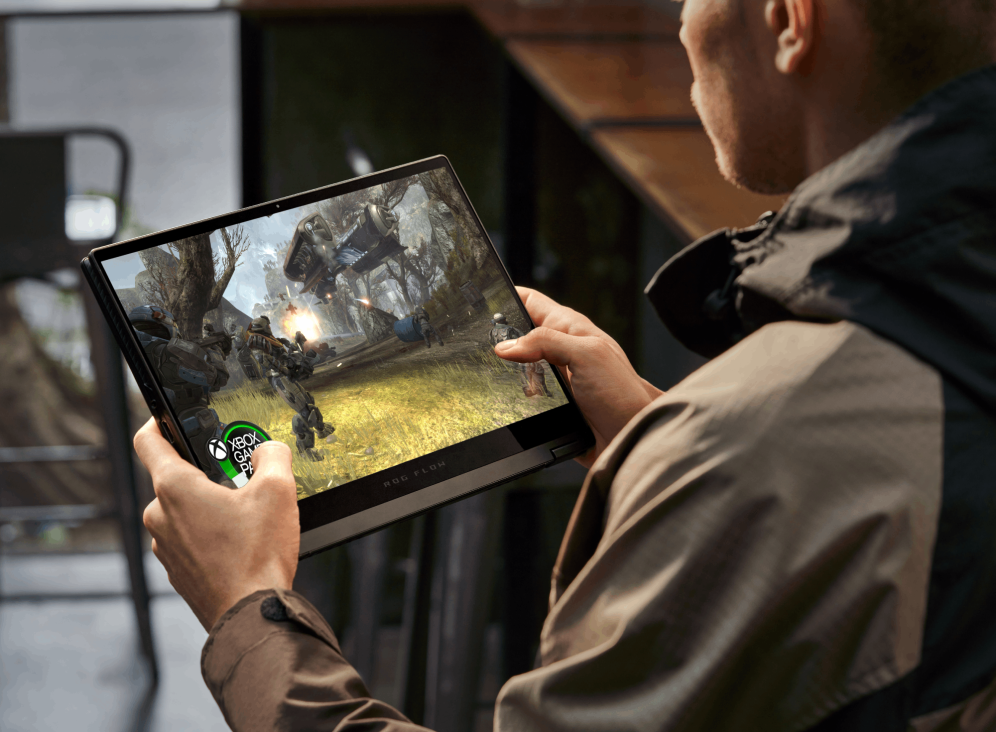 Person holding the Flow X13 in tablet mode, playing Halo: Reach.