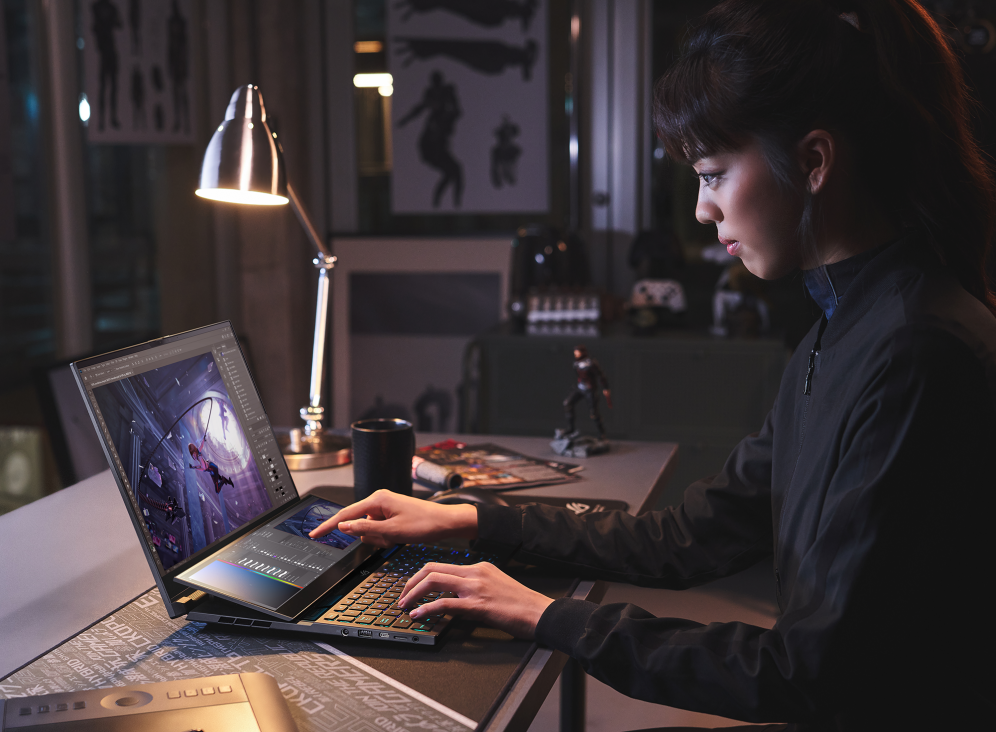 Person at a table, using the Zephyrus Duo 16's second screen to edit a project.