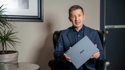 Болат Садыкулов, управляющий партнер группы компаний DAR, держит в руках ноутбук ExpertBook B9 OLED