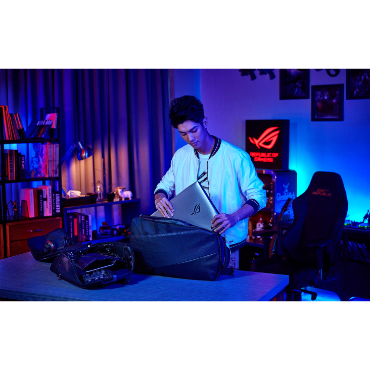 A person putting an ROG G703 into a bag in a gaming room.