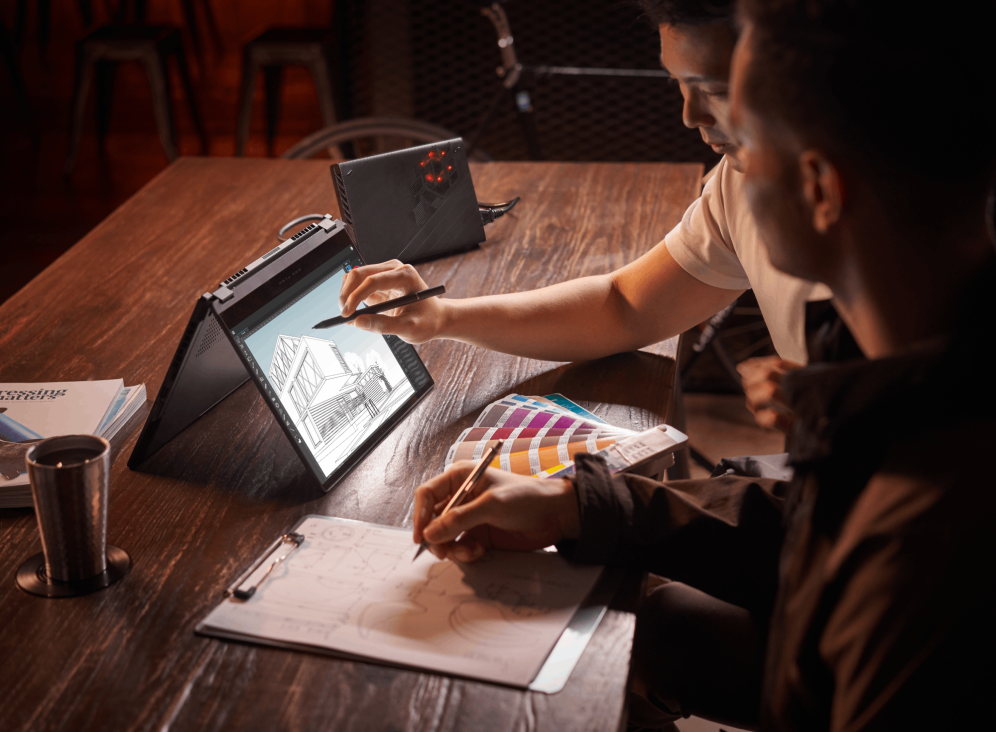 Two men at a desk with a paint strip open, working on an architecture project with the Flow X13 in tent mode and using a stylus.