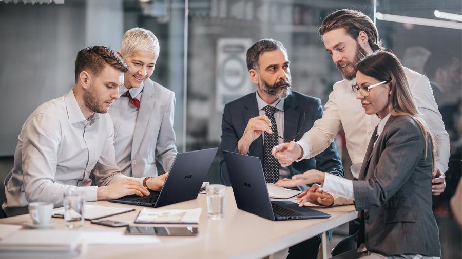 A group of people in a business meeting, sitting around a table with ASUS ExpertBook B5, the World’s Lightest 16-inch Business Laptop.