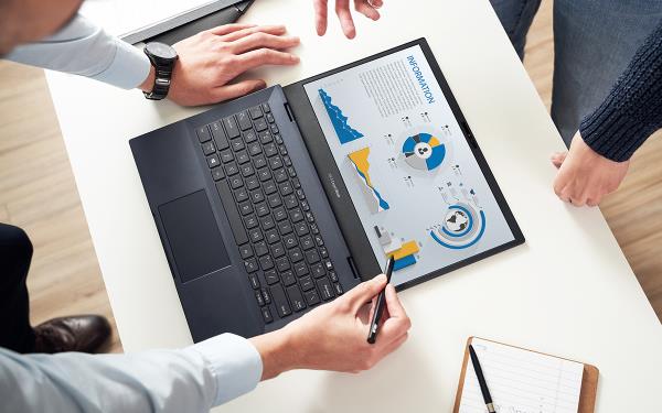 Un portátil ASUS ExpertBook se muestra desde arriba, colocada sobre el escritorio blanco. Dos miembros miran el gráfico que se muestra en la pantalla, mientras que uno de ellos usa un lápiz óptico para interactuar con él.