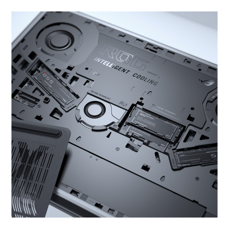 The interior of a laptop showcasing the ROG Intelligent Cooling system with visible fans, RAM, and SSD components