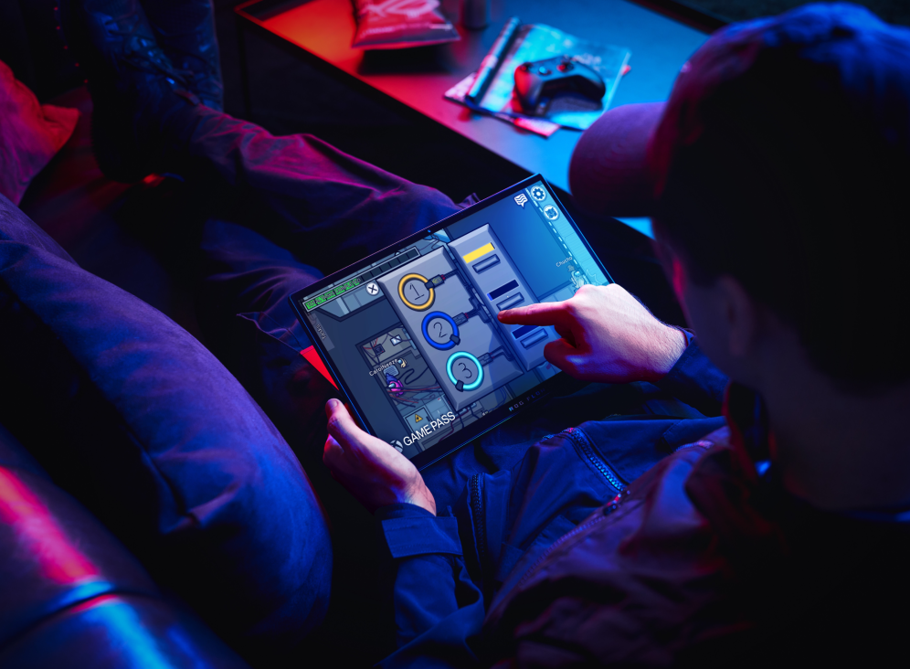 Man reclined on a couch with the Flow Z13 in tablet mode, playing Among Us.