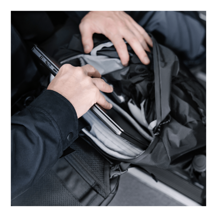 Close-up of a person's hands removing a laptop from a ROG Archer ErgoAir Gaming Backpack