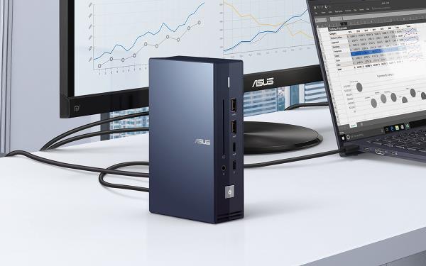 Un ASUS SimPro Dock est montré depuis un léger angle, placé au premier plan, connecté à un moniteur ASUS et à un ordinateur portable ASUS ExpertBook en arrière-plan. 