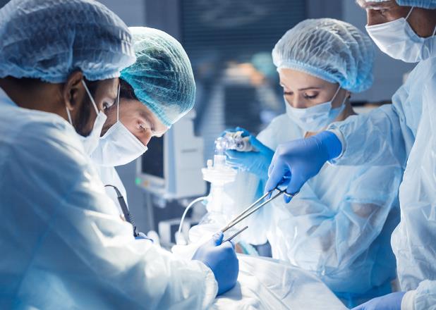 Doctors and assistants performing surgery in operating room