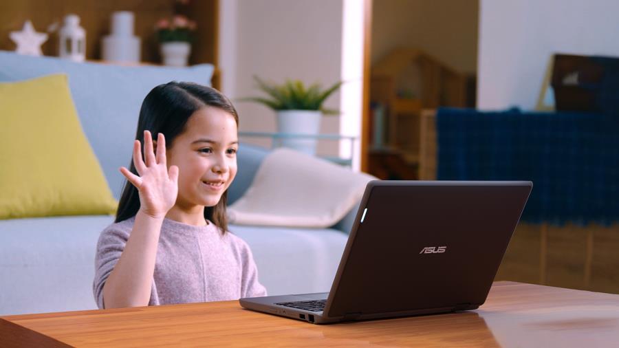 A kid sits in front of ASUS BR1100 which is on the desk and she is looking at the monitor, waving her hand.