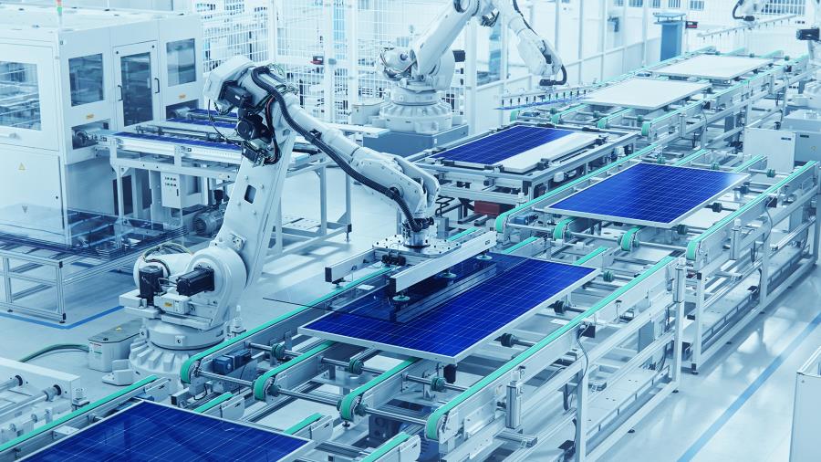 在現代明亮工廠，以廣角鏡頭呈現太陽能電池板生產線和機器人手臂。太陽能電池板正在傳送帶上組裝。
